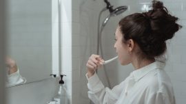 Woman brushing teeth to avoid plaque
